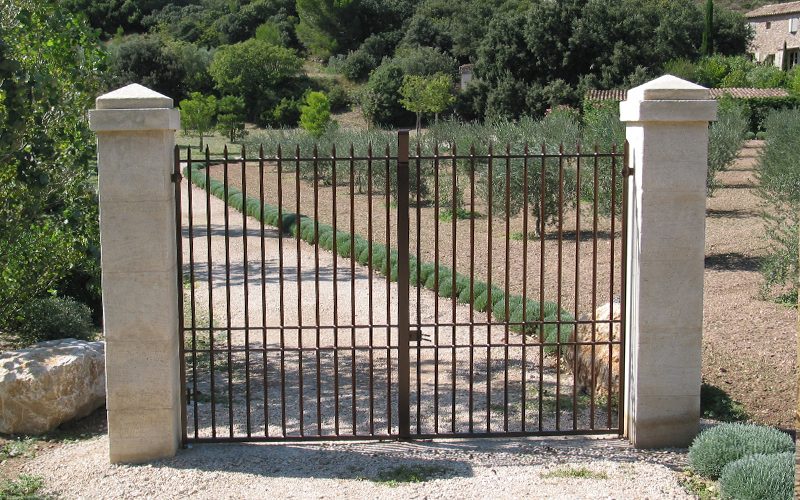 Portail 2 vantaux avec barreaudage rond et pointes de défense et pilastre
